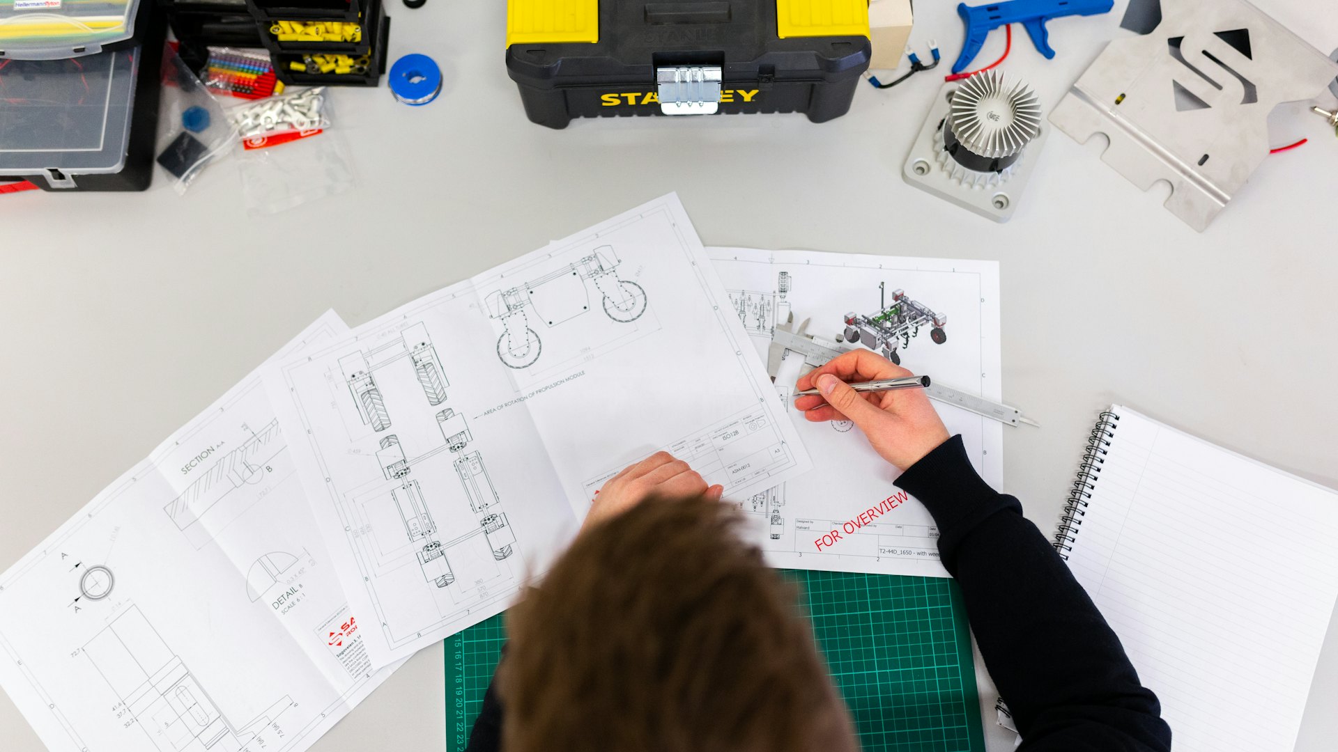 Engineer reviewing technical drawings with tools